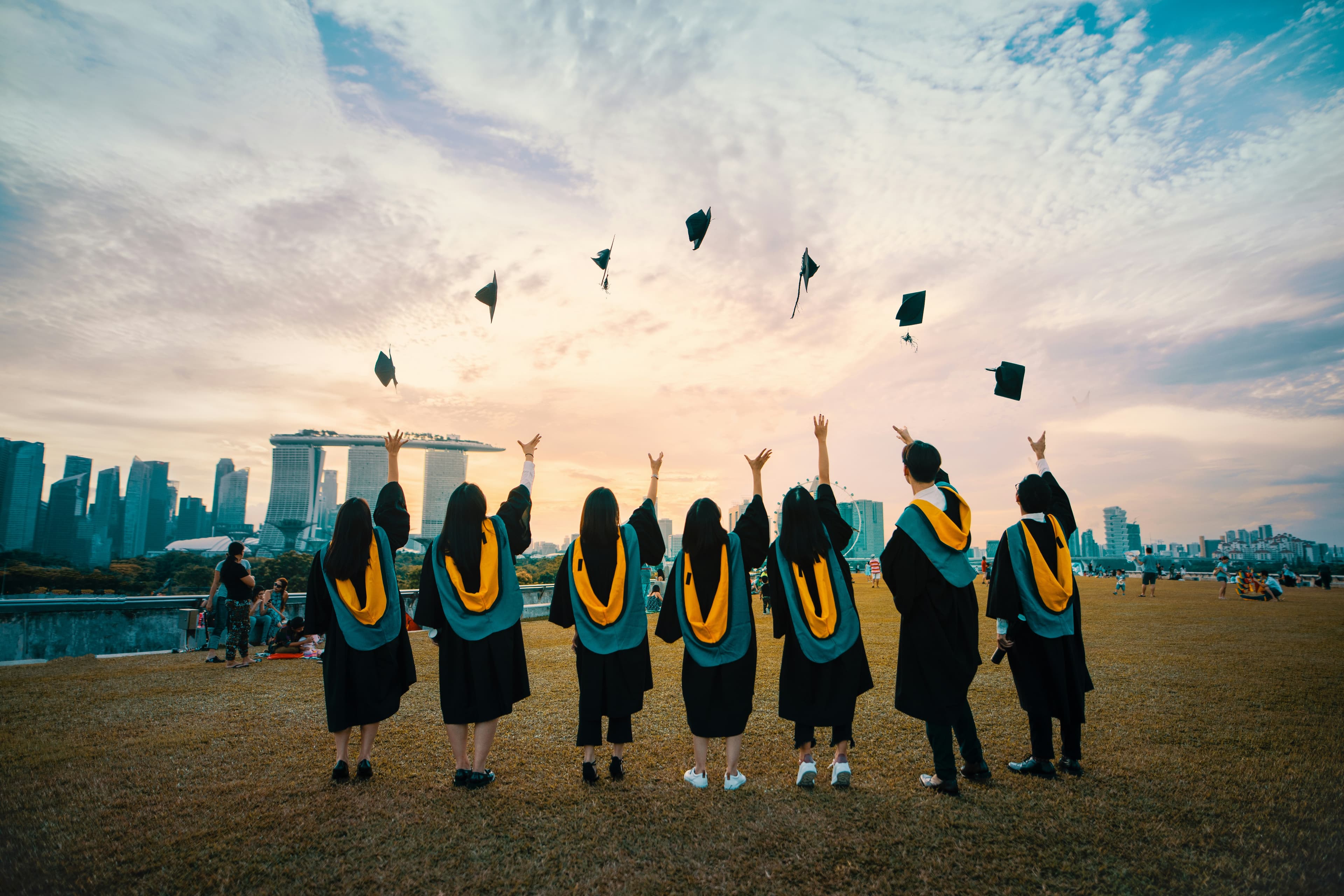 Graduates celebrating near an international city skyline