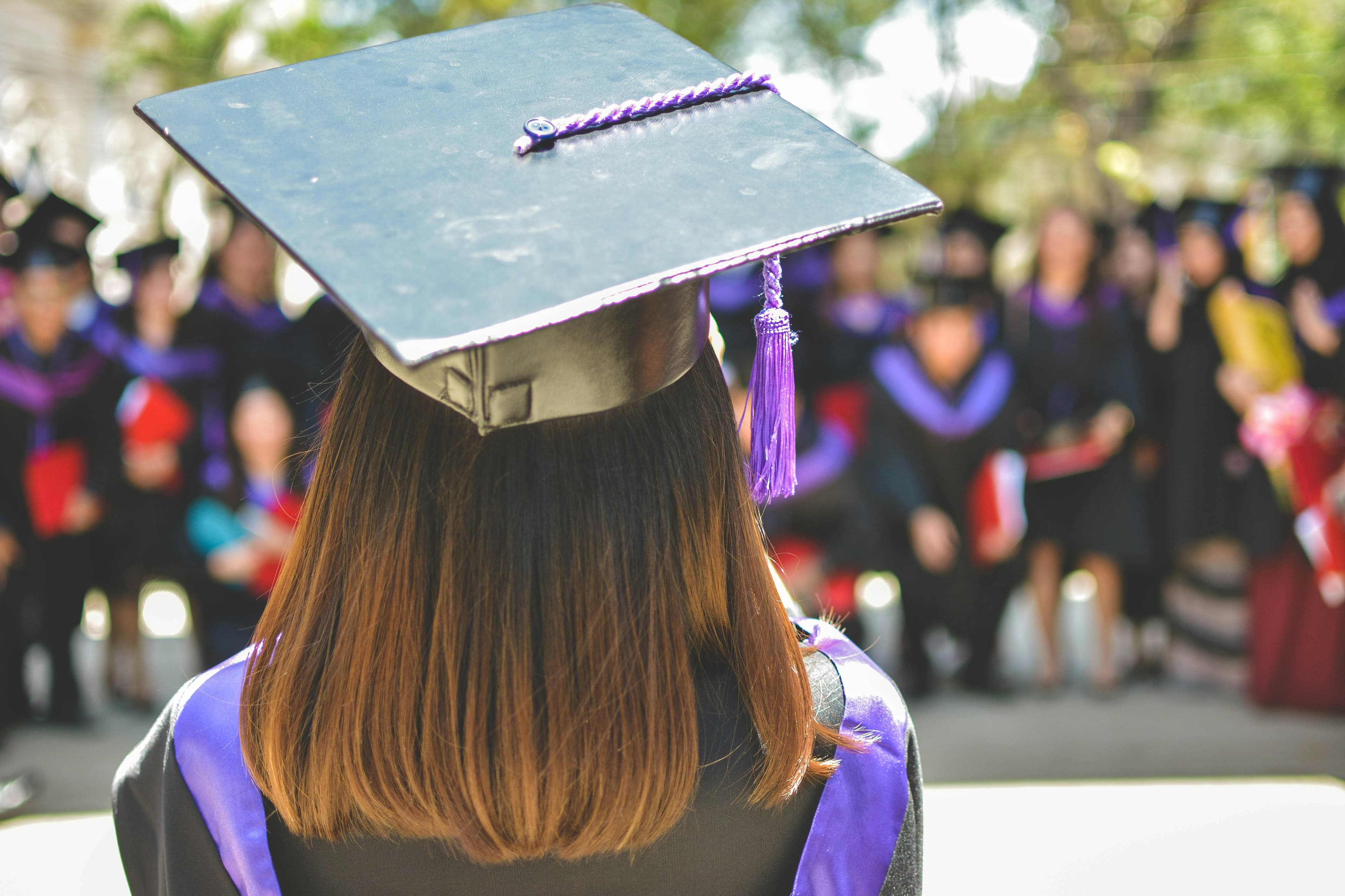 Graduate at a ceremony with classmates in the background
